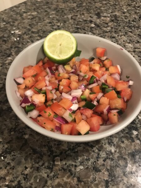 pico de gallow in a bowl with a lime wedge